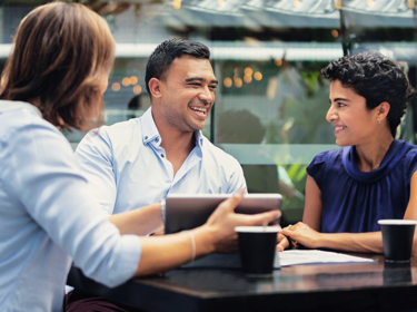 People talking at table with tablet